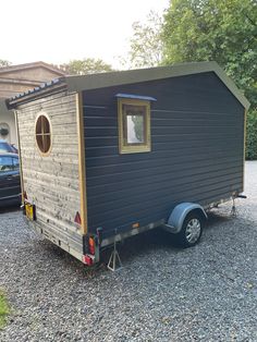 a tiny house is parked in the gravel