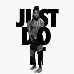 a woman standing in front of the words just do it