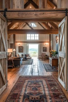 Rustic barndominium interior featuring exposed wooden beams, vintage decor, and a tall ceiling. Cozy seating areas and large windows with countryside views. Barn House Ideas, Small Barn House, House Additions, Countryside Home, Barn Houses, Homestead House, Loft Conversions, Barn Living, Rural Lifestyle