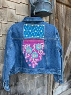 a blue jean jacket hanging on a brick wall