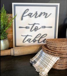 a sign that says farm to table next to some wicker baskets and a potted plant