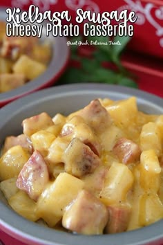 a bowl filled with cheese and ham casserole on top of a red table