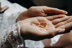 two people holding wedding rings in their hands