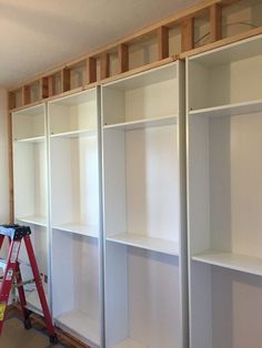 an unfinished room with white shelving being installed