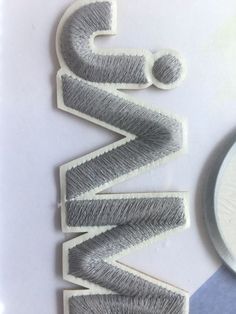 the letters are made out of yarn and have been cut into small pieces with scissors