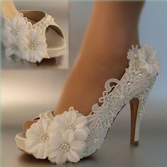 a pair of white high heel shoes with flowers on the toes and heels are shown