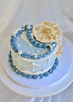 there is a blue and white cake on top of a plate with gold trimmings