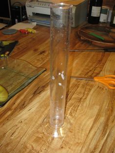 a glass tube filled with liquid sitting on top of a wooden table