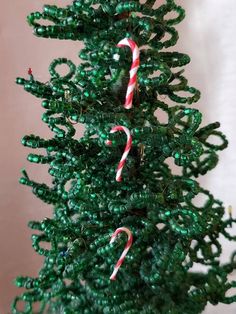 a green christmas tree with candy canes on it