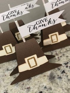 some brown and white paper hats with name tags on them sitting on top of a table