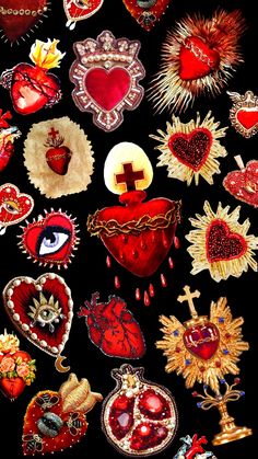 an assortment of heart shaped patches and pins on a black background with red, yellow, orange, and green colors