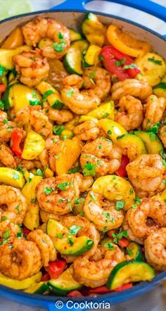 shrimp and zucchini stir fry in a blue skillet