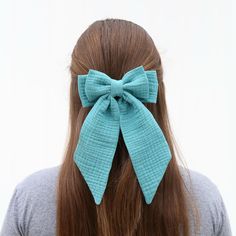 a woman with long brown hair wearing a blue bow