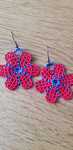 two pink and blue beaded earrings on a wooden table