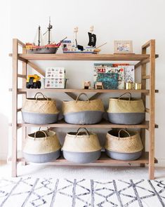 a shelf filled with baskets and toys on top of a rug