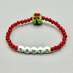 Gemstone Santa beaded stretch bracelet  Genuine red Jade  present is glass approximately 7 inches    strung on professional latex free elastic.  We do our best to choose each stone carefully and purposeful for every piece.. However there might be slight differences in color size shape and clarity which makes each item unique and one of a kind. Each piece of jewelry will come in a colored satin drawstring bag for it's protection and storage or to be ready to give as a gift. Our gemstone jewelry are all original designs by Lisa Beth and LDE Affinity Jewelry. They are hand crafted with passion and love in our Southern California studio. WE WANT TO THANK YOU FOR TAKING THE TIME TO VISIT OUR SHOP! If you'd like to stay up to date with our latest creation or collection, please add our store to y Plastic Letters, Red Jade, Jade Crystal, Beads Bracelet Design, Christmas Bracelet, Jewelry Beaded, Bead Bracelets, Holiday Jewelry, Seed Bead Bracelets