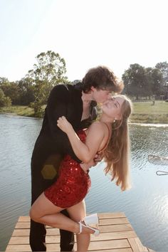 a man and woman are kissing on a dock