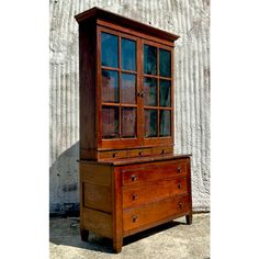 an old wooden dresser with glass doors on top