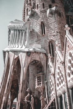 a tall building with statues on the side of it's sides and an ornate tower