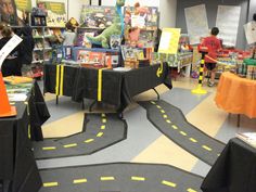 children's books and toys are on display in a library with black tablecloths