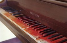 an old piano with red and black keys