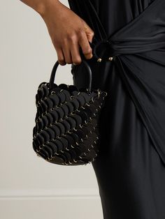 Rabanne's bucket bag is a modern reinterpretation of the house's chainmail accessories from the '60s. It's crafted from layered leather discs connected by gold-tone rings and has a detachable shoulder strap. It will fit your phone, sunglasses and keys. Modern Leather Bucket Bag For Parties, Leather Top Handle Bucket Bag For Party, Leather Bucket Bag With Detachable Handle For Party, Leather Bucket Bag For Party, Leather Party Bucket Bag With Detachable Handle, Black Bucket Bag With Round Handle For Evening, Black Evening Bucket Bag With Round Handle, Designer Evening Bucket Bag With Metal Hardware, Modern Bucket Bag With Chain Strap For Evening