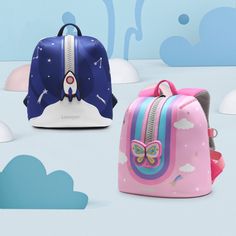 three children's backpacks with colorful designs on them and clouds in the background