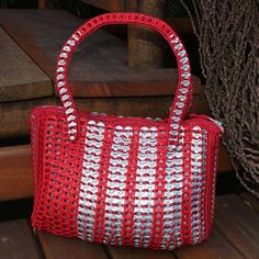 a red and white purse sitting on top of a wooden bench