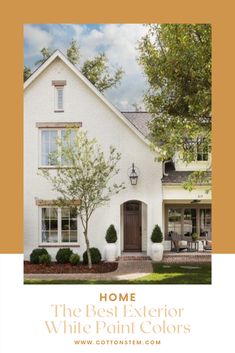 a white brick house with trees and shrubs in front of the entrance to the home