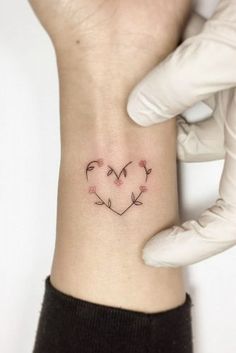 a small heart tattoo on the wrist