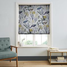 a living room with a chair and window covered in blue fabric, next to a white coffee table