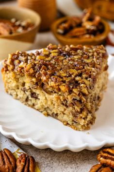 a slice of pecan pie on a white plate with pecans around the edge