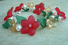 a bracelet with red flowers and green leaves is shown on the floor in front of a white background