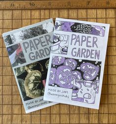 two paper garden books sitting on top of a bamboo mat