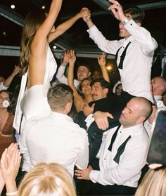 a group of people standing around each other in front of a man on the dance floor