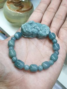 "17 pieces, Type A natural Jadeite beads (all non-bleached, non-dyed, non-treated) of blue color, glossy, semi-translucent, 9 mm (barrel) and 7 mm (round) in sizes. Jade Pixiu is also Type A, natural Jadeite, glossy, semitranslucent, marbled blue color and bears the Money / Coin symbol on the back; 4 cm x 2.5 cm x 1.4 cm. Whole bracelet weighs 50 grams. Bracelet size is set at 17 cm but in case it needed downsizing or resizing (up to 19 cm) just let us know immediately after payment by messaging us at \"Message Seller\" under the listing title. Bracelet also comes with extra sets of elastic strings, an open wire and 4 pcs of spare Jade beads (2 barrels, 2 rounds) (on top of size 17 cm)." Blue Jade Beaded Bracelet For Healing, Handmade Blue Jade Beaded Bracelet, Blue Jade Beaded Bracelets For Healing, Blue Jade Bracelets For Healing, Handmade Blue Jade Beaded Bracelets, Blue Jade Spiritual Bracelets, Spiritual Blue Jade Bracelets, Blue Jade Bracelets With Natural Stones, Blue Jade