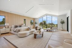 a large living room with lots of windows and furniture on the floor in front of it