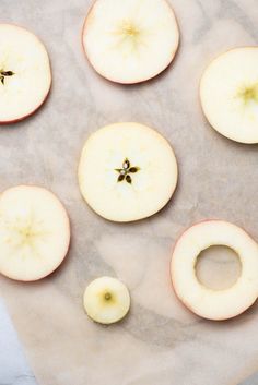 apples are cut up and placed on a piece of parchment paper with the peels removed