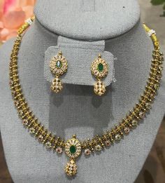 Enhance your beauty with this radiant gold-plated necklace, featuring a delicate design adorned with stunning green and white cubic zirconia (CZ) stones. Complemented by matching earrings, this set exudes elegance and grace, making it perfect for any special occasion. Features: *Design: Elegant gold-plated necklace with intricate detailing *Stones: Adorned with high-quality green and white CZ stones for a dazzling effect *Earrings: Matching earrings included to complete the set *Materials: Gold Gold Plated Green Emerald Necklace, Green Round Gold Plated Emerald Necklace, Round Green Emerald Gold Plated Necklace, Green Round Emerald Gold Plated Necklace, Round Green Emerald Gold-plated Necklace, Anniversary Gold Cubic Zirconia Kundan Necklace, Green Temple Jewelry Set For Anniversary, Green Diamond Temple Jewelry Necklace, Dazzling Green Necklaces With Sparkling Stones