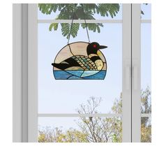 a stained glass bird hanging from a window