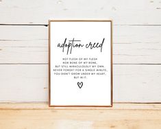 an art print with the words adopton cred and a heart in it on a wooden background