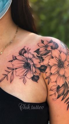 a woman's shoulder with flowers on it and a mask covering up her face