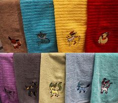 the towels are all different colors and have pokemon embroidered on each one, along with other designs