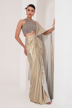 Grey and gold toned pre-draped saree crafted in metallic georgette. Paired with a sleeveless halter neck blouse with tonal crystal tassel and cutdana embellishments. - Aza Fashions Fitted Gold Pre-draped Saree For Festive Occasions, Glamorous Gold Blouse Piece For Designer Wear, Gold Pre-draped Saree For Diwali Reception, Gold Pre-draped Saree For Reception And Festive Occasions, Gold Fitted Pre-draped Saree For Reception, Designer Wear Fitted Gold Saree, Designer Gold Fitted Saree, Glamorous Gold Blouse Piece For Diwali, Glamorous Gold Saree For Designer Wear