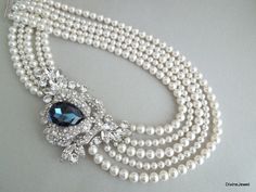 "This glamorous necklace has a dramatic brooch enhanced with a Montana teardrop and navettes, and Swarovski pearls in your choice of color. Brooch measures 4 1/4\" by 2 3/4\" at it widest point, and has a huge Swarovski teardrop crystal 30 x 20 mm placed in the middle in Montana blue and clear rhinestones. This multiple strand necklace measures 17 1/2\" long inner strand. Pearls measure 8 and 6 mm. Finished off with a five strand tube clasp for a very secure hold! Please choose desired pearl col Statement Necklace Wedding, Bridal Backdrop Necklace, Backdrops Necklace, Bridal Pearl Necklace, Pearl Necklace Wedding, Necklace Wedding, Necklace Pearl, Rhinestone Wedding, Necklace Statement