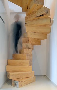 a man is walking up some stairs made out of wood