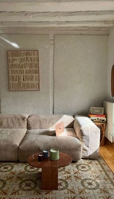 a living room with a couch, coffee table and rug on the floor in front of it