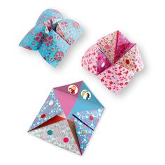 three origami boxes with different designs on them, one in pink and the other in blue