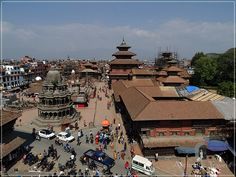 an aerial view of a city with lots of buildings and people walking on the street