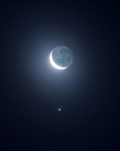 the moon and two stars are seen in the sky